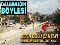 Aracın üstünde unutulan altın dolu çanta yola düştü