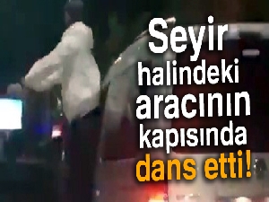 Seyir halindeki aracının kapısında dans etti