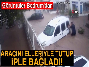 Selde sürüklenen aracını elleriyle tuttu, park etti, iple bağladı