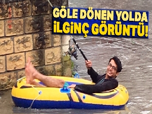 Göle dönen yolda şişme botuyla kürek çekti