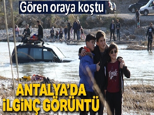 Kanalın ortasında mahsur kalan aracın önünde poz verdiler