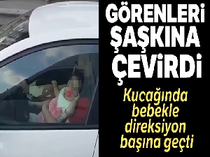 Kucağında bebek ile direksiyon başına geçen sürücü kamerada