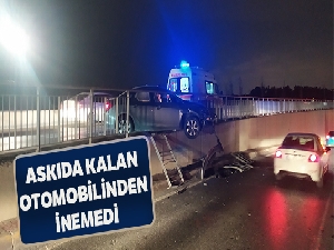Bariyerlerde askıda kalan otomobilden düşme tehlikesine rağmen inmedi