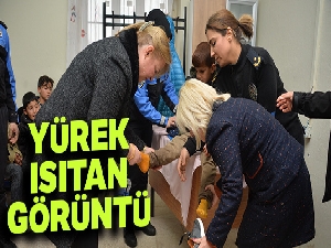 Islak çorabını çıkardığı öğrencinin ayağını mendille kuruladı