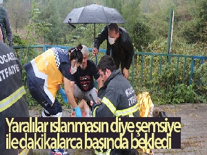 Yağan yağmurda yaralılar ıslanmasın diye şemsiyesini açarak dakikalarca bekledi