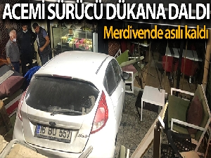 Otomobil dükkana dalıp merdivenlerde asılı kaldı
