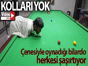 Kolları olmayan adam çenesiyle bilardo oynayarak hünerlerini sergiliyor