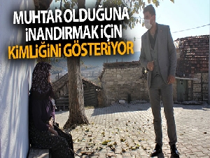Muhtar olduğuna inandırmak için kimliğini gösteriyor