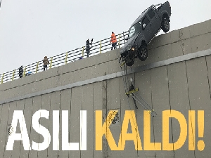 Yoldan çıkan kamyonet köprüde asılı kaldı