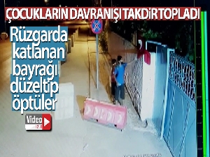 Rüzgarda katlanan bayrağı düzeltip öptüler