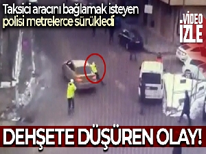 Taksicinin aracını bağlamak isteyen polisi sürüklediği anlar kamerada
