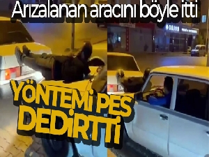 İki otomobilin arasına uzanıp, arızalanan aracı ayaklarıyla itti