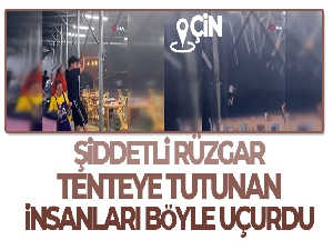 Çin'de şiddetli rüzgar tenteye tutunan insanları uçurdu