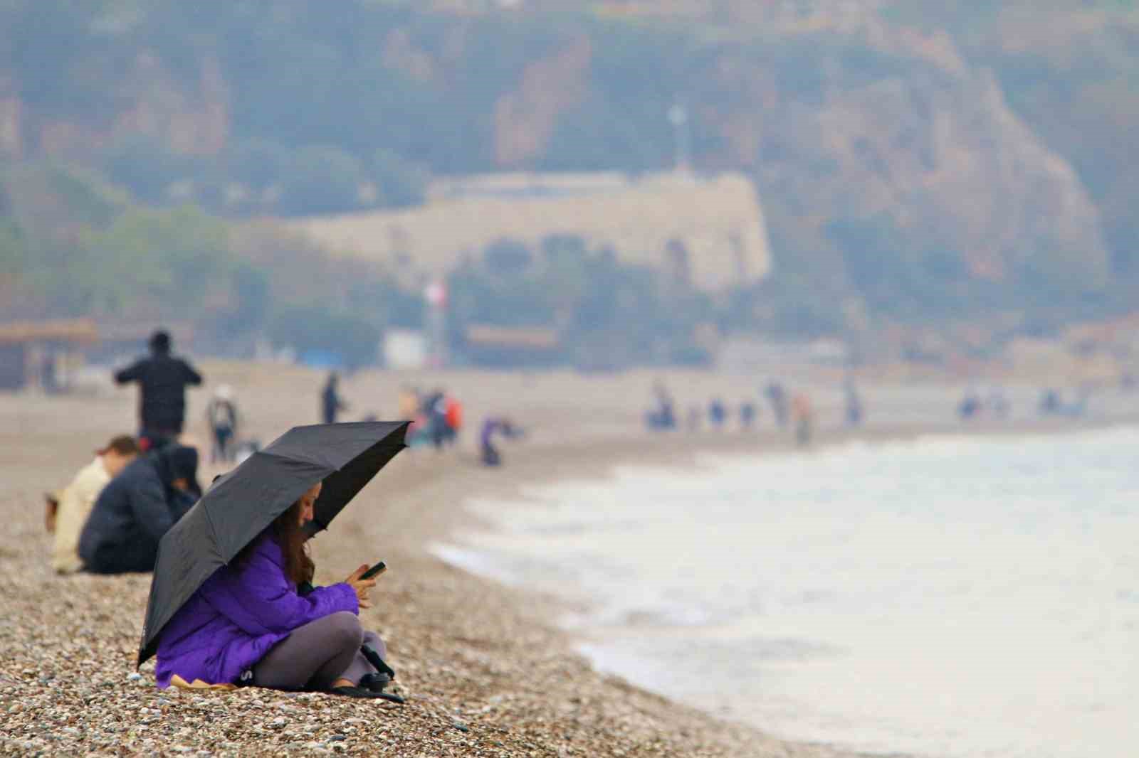 Antalya’da yağmura rağmen şemsiye altında deniz keyfi