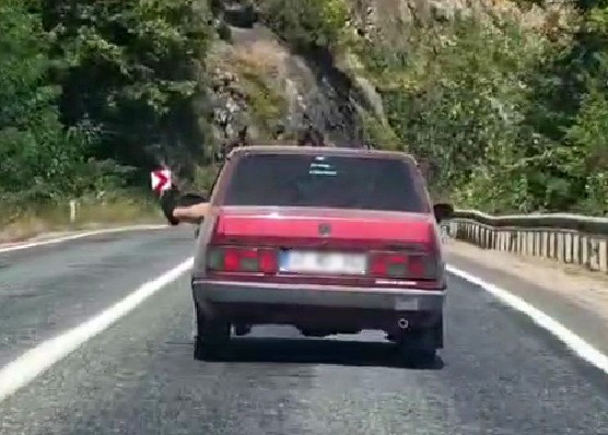 ayaklarini-camdan-sarkitarak-trafigi-tehlikeye-atti