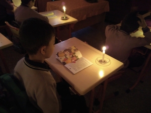 Minik Öğrenciler Mum Işığı Eşliğinde Kitap Okuyor